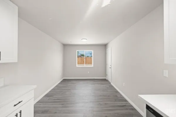 a view of a kitchen with wooden floor and electronic appliances