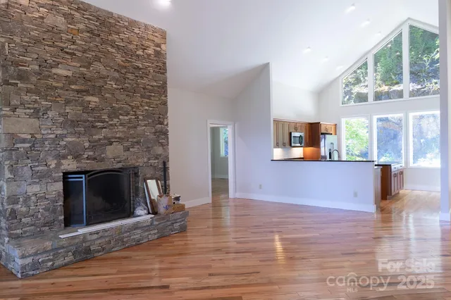 a view of an empty room and window and wooden floor