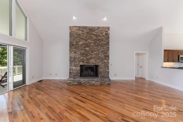 a view of empty room with wooden floor and fireplace