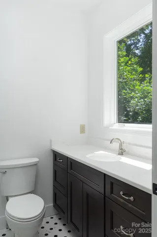 a bathroom with a sink a toilet and a window