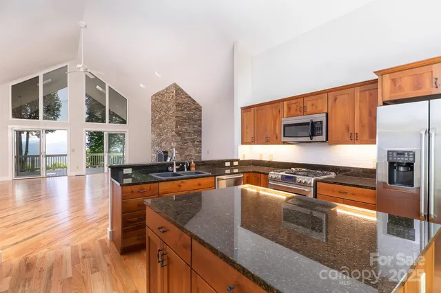 a kitchen with stainless steel appliances granite countertop a stove a sink and a microwave