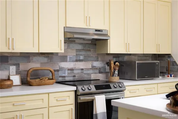 a kitchen with stainless steel appliances granite countertop a stove and a white cabinets