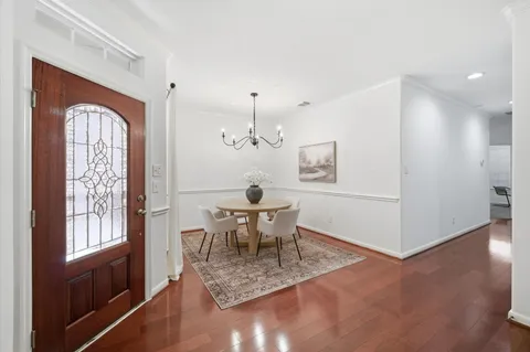 a dining room with wooden floor and a chandelier