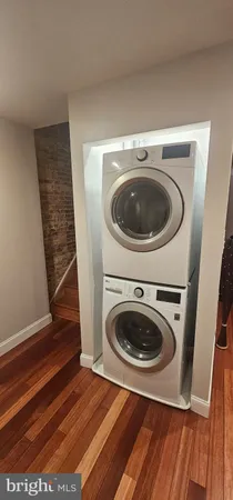 a utility room with wooden floor washer and dryer