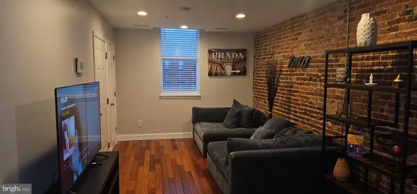 a living room with furniture a wooden floor and a window