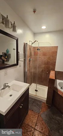 a bathroom with a sink mirror and shower