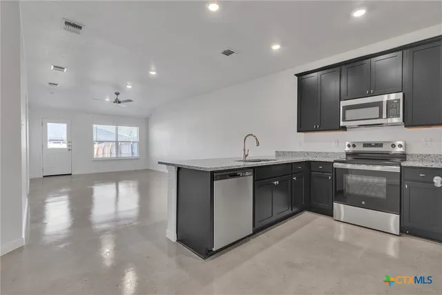 a kitchen with stainless steel appliances granite countertop a sink and stove top oven