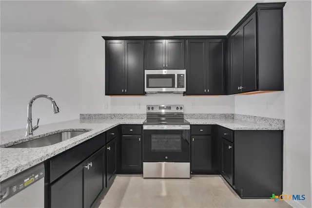 a kitchen with a sink and a stove top oven