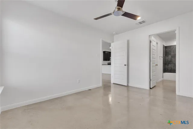 an empty room with closet and windows