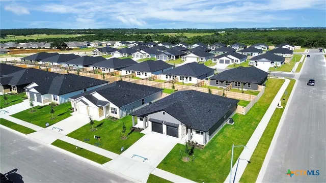 an aerial view of residential houses with outdoor space and street view