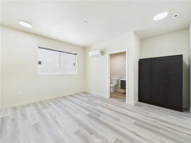 an empty room with closet and windows