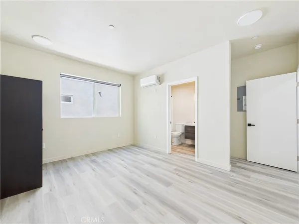 a view of an empty room with wooden floor and closet