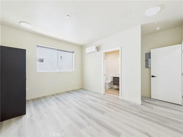 a view of an empty room with wooden floor and closet