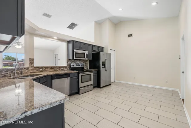 a kitchen with stainless steel appliances granite countertop a sink and cabinets