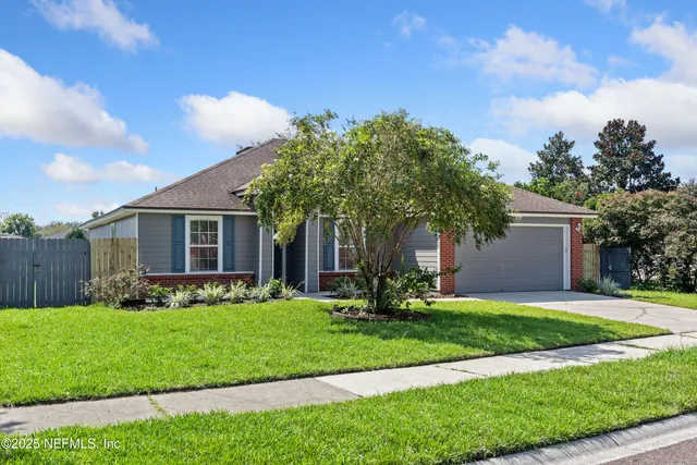 a front view of a house with a yard and trees