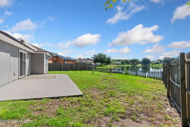 a view of a backyard with grass and a garage
