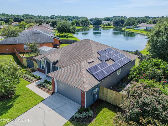 an aerial view of a house with swimming pool and lake view