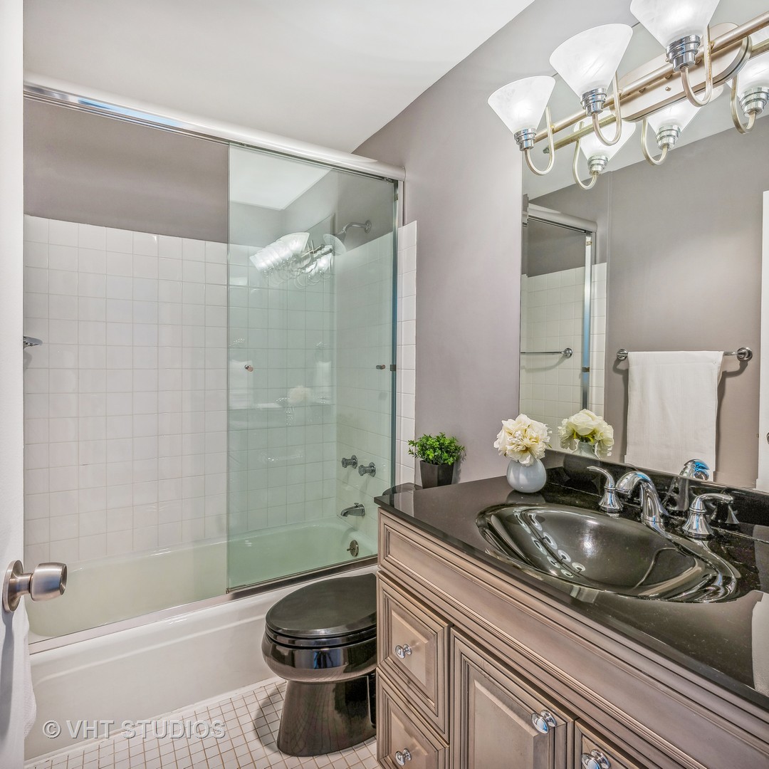 1850 North Clark Street, Unit 503 Chicago, IL 60614 - Photo 14 of 24 a bathroom with a granite countertop sink a toilet and shower