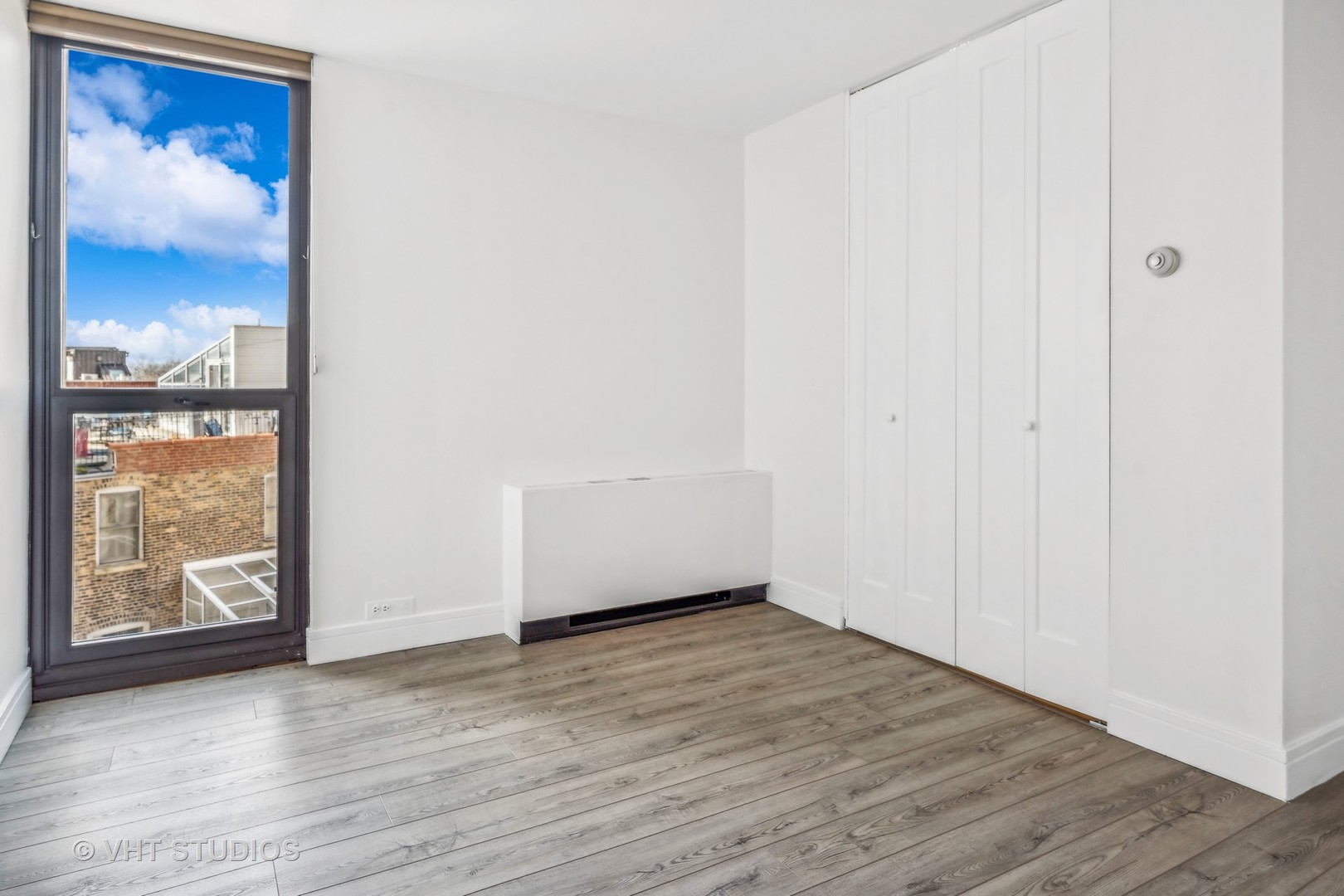 1850 North Clark Street, Unit 503 Chicago, IL 60614 - Photo 16 of 24 a view of an empty room with wooden floor and a window