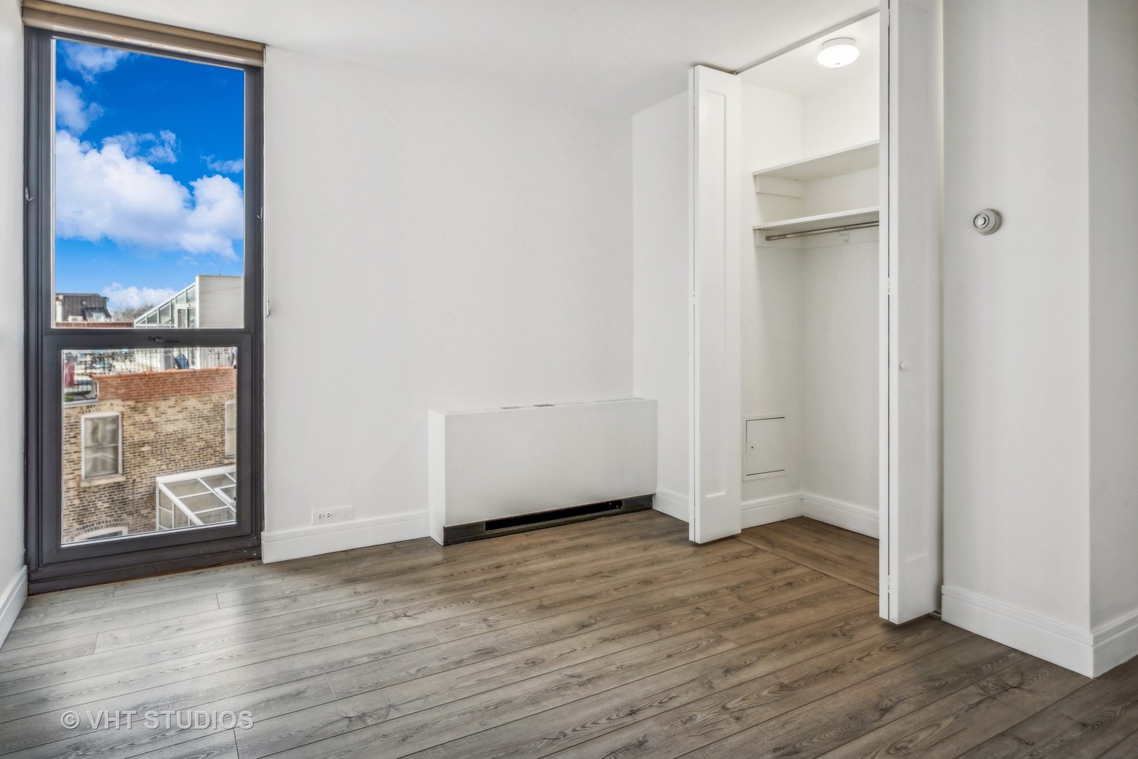 1850 North Clark Street, Unit 503 Chicago, IL 60614 - Photo 17 of 24 a view of an empty room with wooden floor and a window