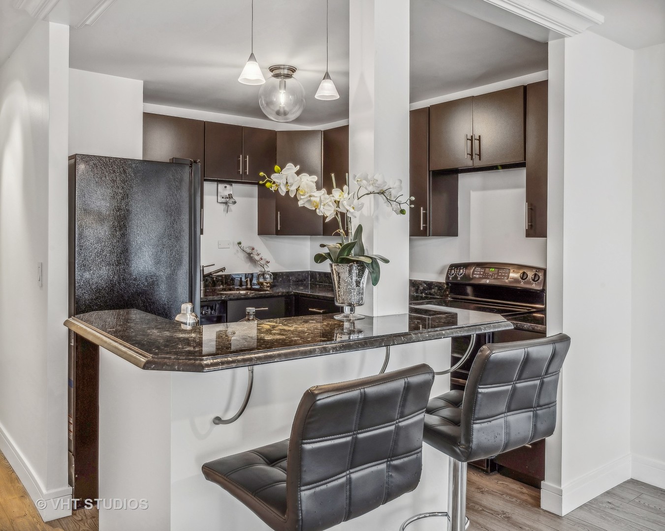 1850 North Clark Street, Unit 503 Chicago, IL 60614 - Photo 7 of 24 a kitchen with kitchen island stainless steel appliances a sink stove and refrigerator