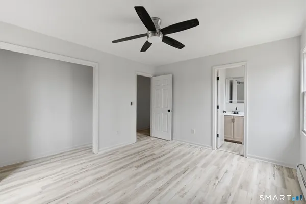a view of empty room with window and wooden floor