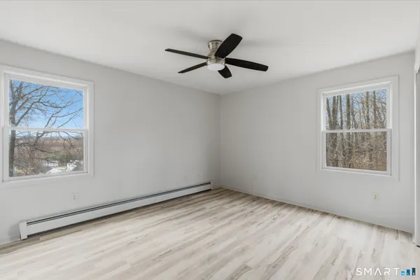 a view of empty room with wooden floor