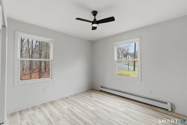 a view of a room with a ceiling fan and wooden floor