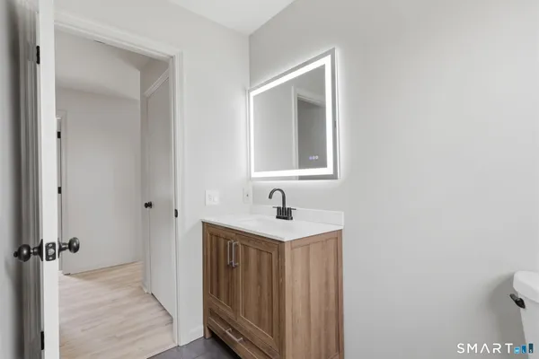 a bathroom with a toilet sink and mirror