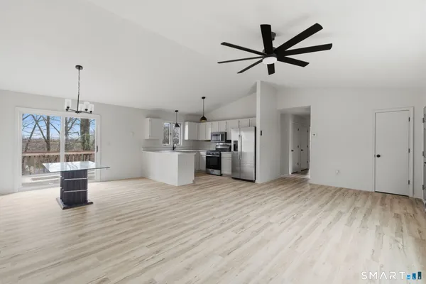 a view of empty room with wooden floor and ceiling fan
