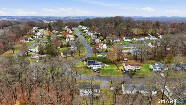 an aerial view of residential houses with outdoor space and trees