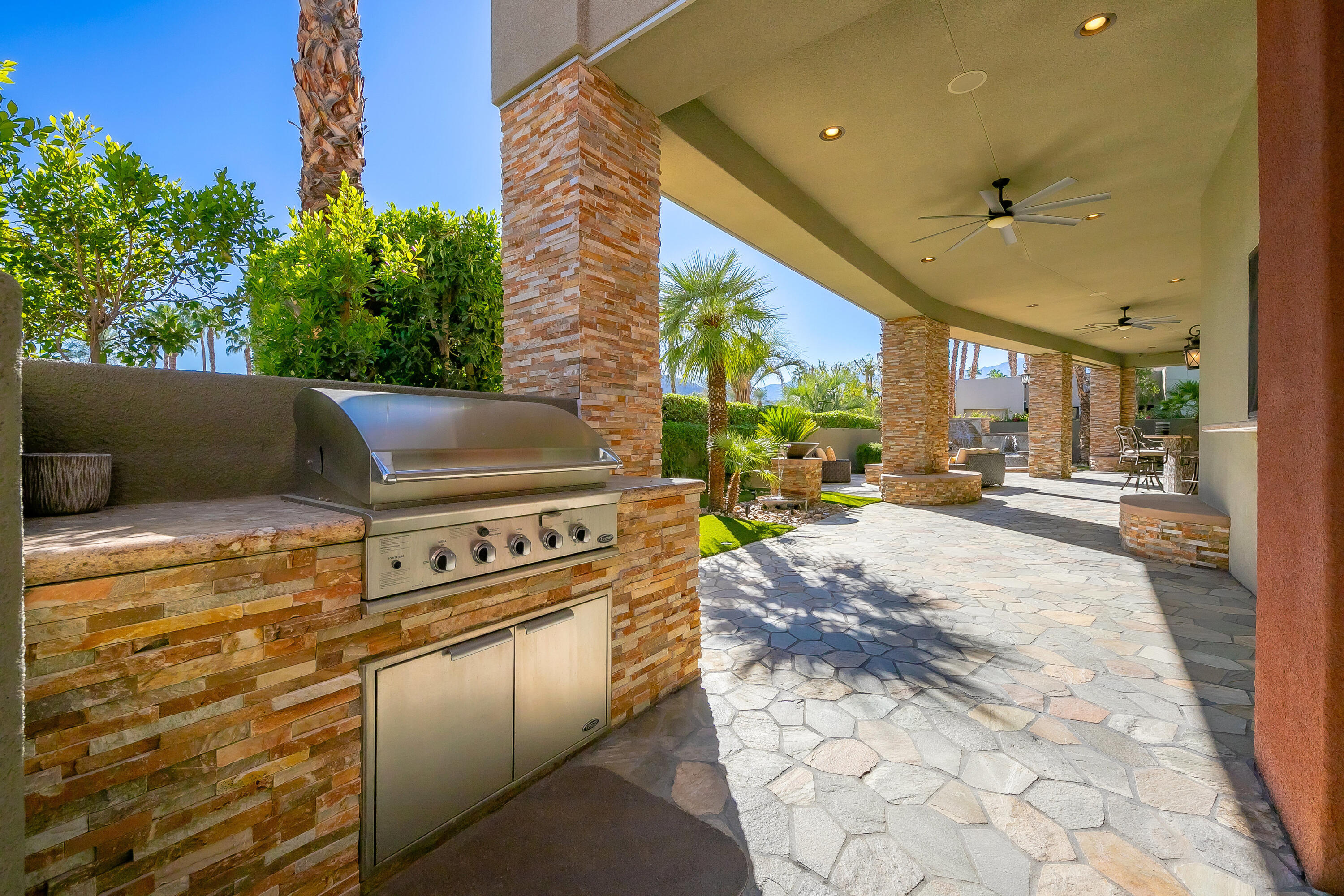 15 Sun Ridge Circle Rancho Mirage, CA 92270 - Photo 27 of 53 a view of a patio with table and chairs a barbeque and potted plants