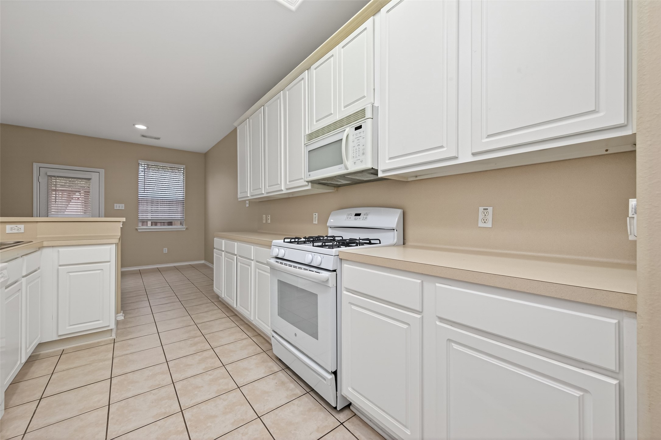 169 Musewood Court Spring, TX 77382 - Photo 15 of 44 a kitchen with granite countertop white cabinets and white appliances