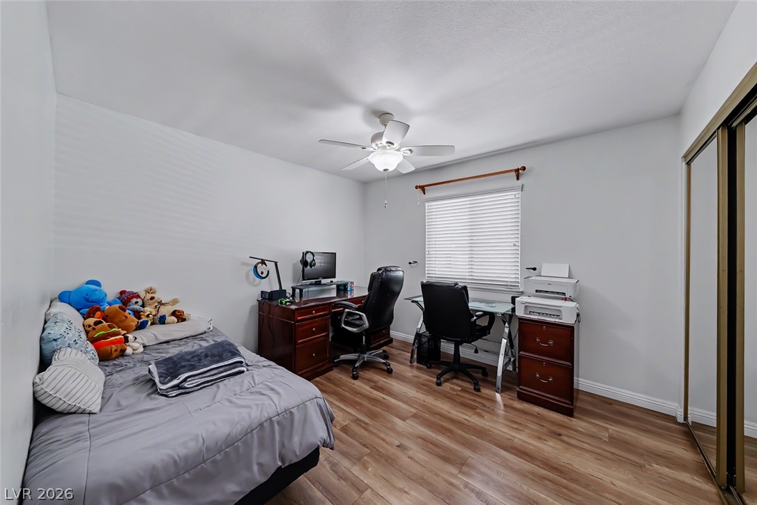 3107 Trueno Road Henderson, NV 89014 - Photo 27 of 37 Well-lit room featuring hardwood flooring and a functional ceiling fan for comfort.