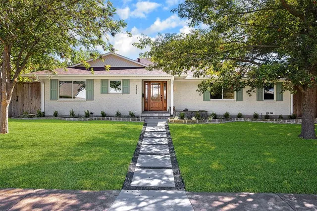 a front view of a house with a garden and yard