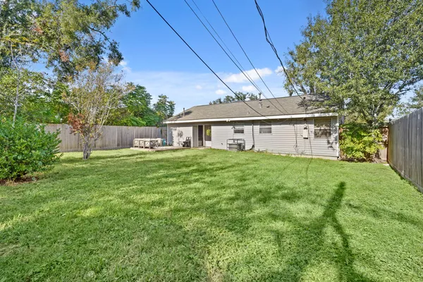 a view of a house with backyard and a tree