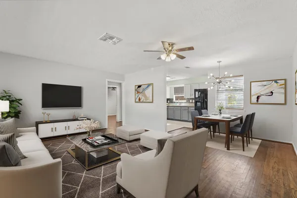 a living room with furniture a wooden floor and a flat screen tv