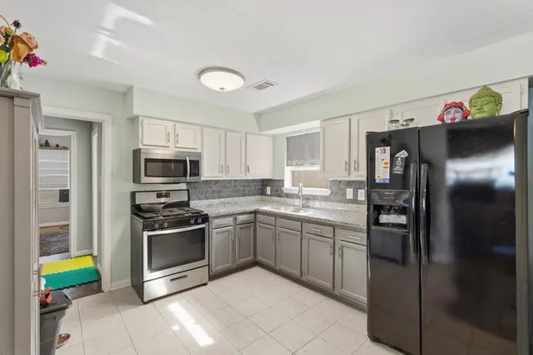 a kitchen with stainless steel appliances granite countertop a refrigerator and a stove top oven