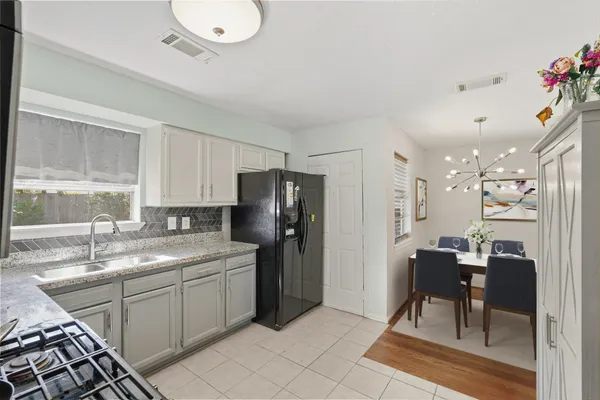 a kitchen with a sink chairs and refrigerator