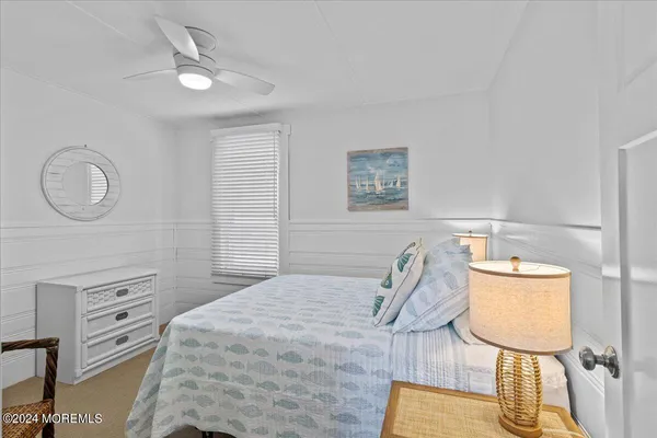 a bedroom with a bed a lamp and a dresser