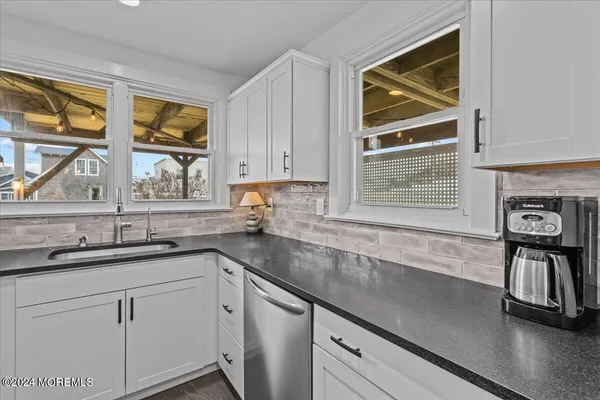 a kitchen with stainless steel appliances granite countertop a sink a stove and cabinets