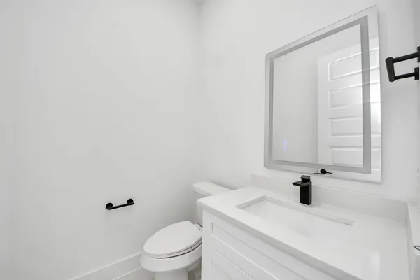 a bathroom with a sink a toilet and a mirror