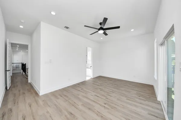 a view of a room with wooden floor and ceiling fan