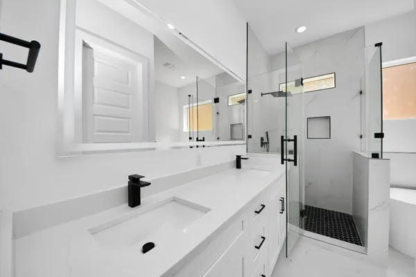 a bathroom with a sink a tub and a mirror