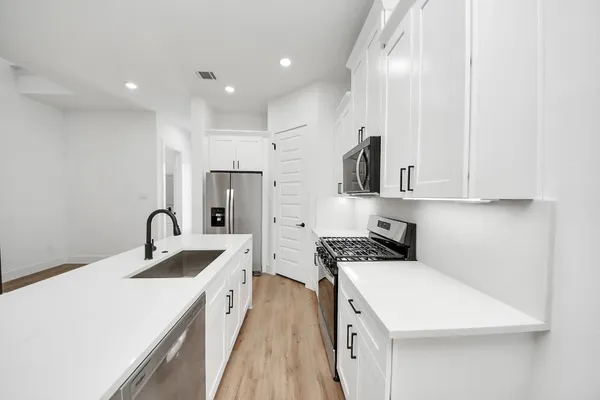 a kitchen with stainless steel appliances granite countertop a sink stove and refrigerator
