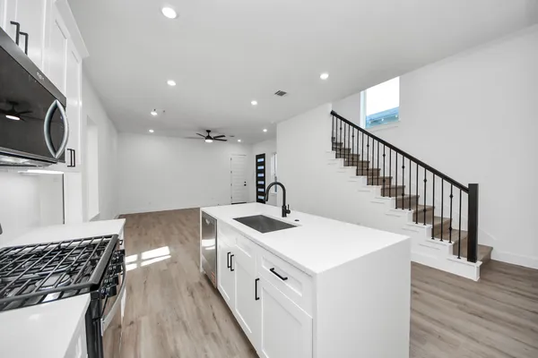 a kitchen with sink a stove and cabinets