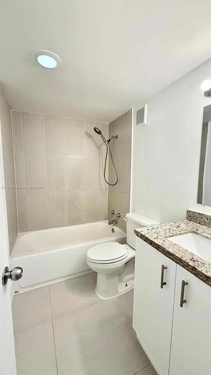 42 Southwest 14th Street, Unit 103 Dania Beach, FL 33004 - Photo 13 of 18 a bathroom with a granite countertop sink toilet a mirror and bathtub