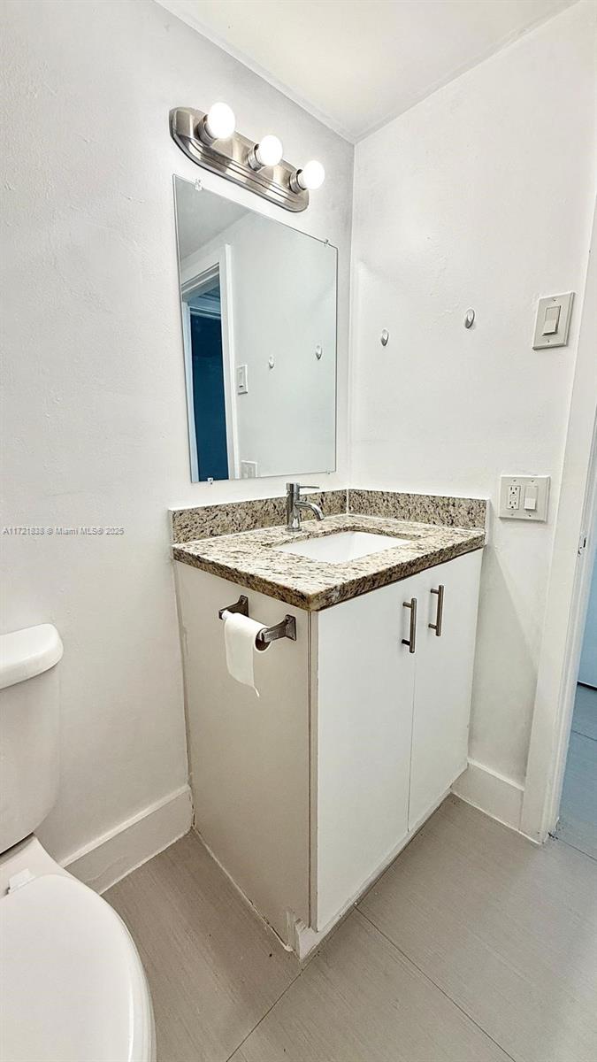 42 Southwest 14th Street, Unit 103 Dania Beach, FL 33004 - Photo 14 of 18 a utility room with a sink a toilet and mirror