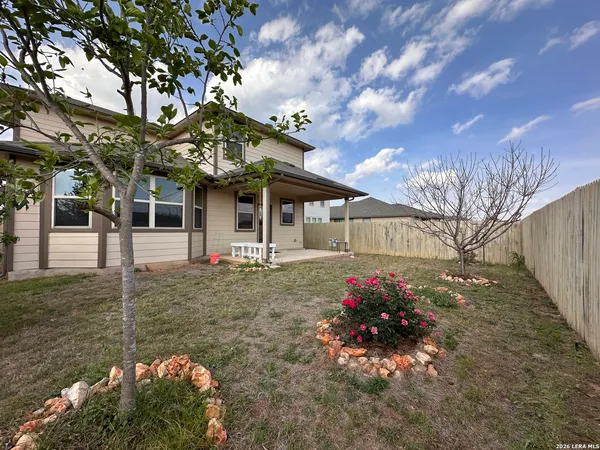 a front view of a house with a yard and a garden