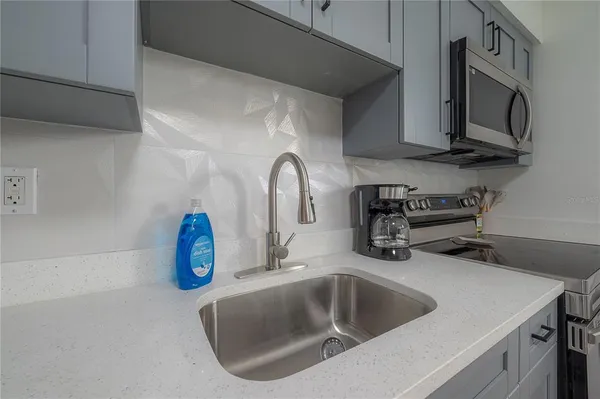 a kitchen with stainless steel appliances granite countertop a sink a microwave and cabinets